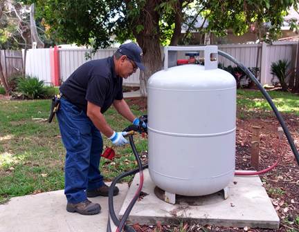 A technician carefully handling and professional refilling a propane tank, ensuring safe and efficient propane service at a residential or commercial property.