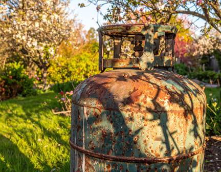 An old rusted propane tank showing signs of wear and corrosion, highlighting the need for a safe and timely a old rusted propane tank that need replacement.