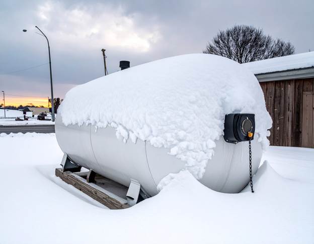 Commercial propane tank covered in snow, highlighting the importance of Propane maintenance Dauphin County businesses must follow.