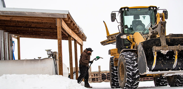 Man walking to fuel up off-road equipment in the winter using Central Penn Propane for reliable energy.