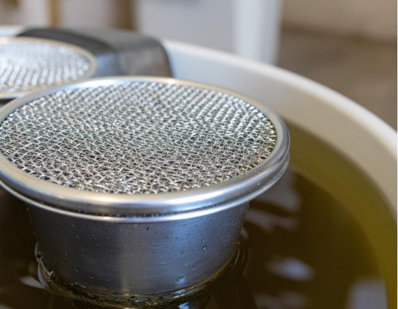 A set of clean diesel fuel filters arranged on a work surface beside maintenance tools, showing the components used to keep a fuel tank system free of debris and contaminants. The image highlights the filtration parts, clean condition, and service environment to illustrate proper diesel equipment upkeep and fuel system protection.