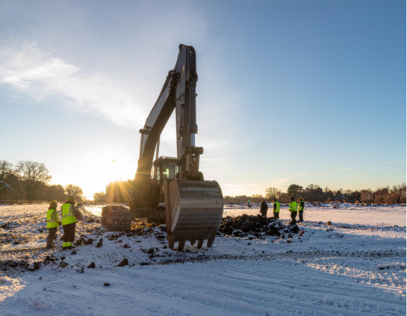 Winter Excavator Digging in Berks County - Central Penn Propane An excavator digging a trench in the snow in Berks County, showing winter construction operations and equipment handling in cold conditions.